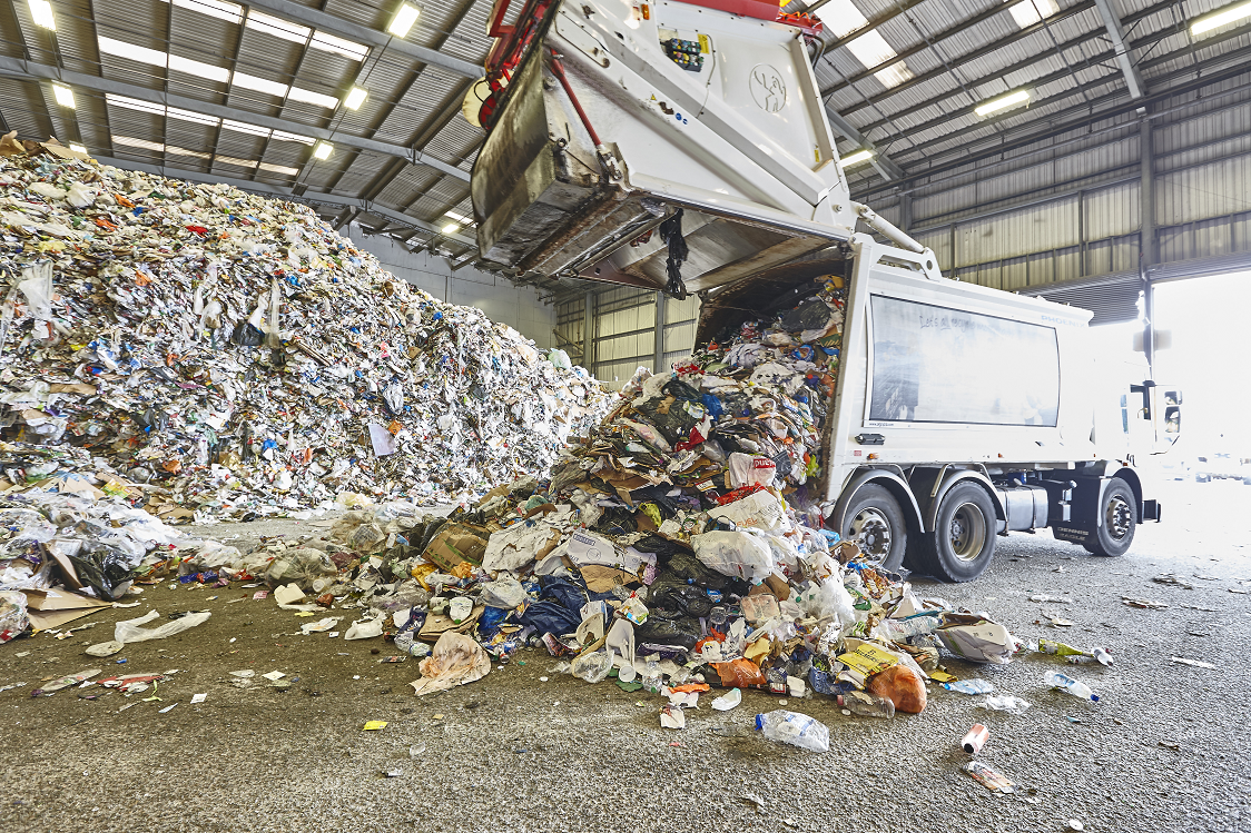 A truck depositing mixed recyclables into a recycling facility