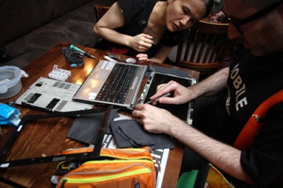 Two people repairing a laptop