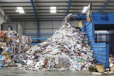 Waste falling from conveyor belt at a recycling facility