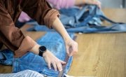 Fashion designer cutting old clothes for reuse