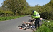 Officer in high viz inspecting flytipping on a roadside