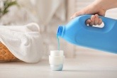 hand pouring detergent into lid