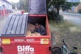 A man sitting in a waste container