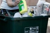 A person placing recycling in a bin
