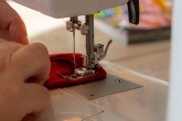 Person using a sewing machine to sew fabrics