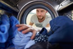 Person pulling clothes out of a washing machine