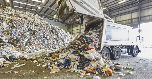 Recyclables being emptied out back of waste vehicle