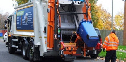 Waste collection service emptying a bin